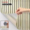 A hand is shown touching a brown plaid peel and stick wallpaper sample, demonstrating its thickness of 2mm.