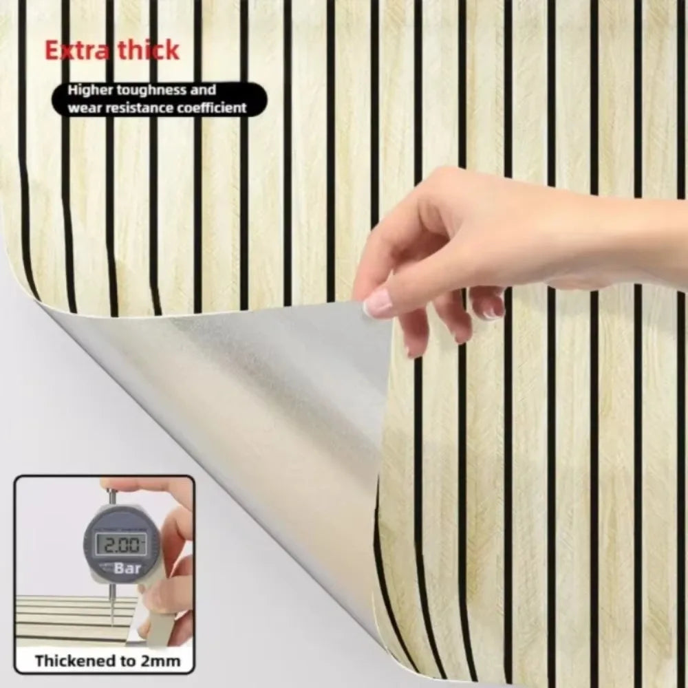 A hand is shown touching a brown plaid peel and stick wallpaper sample, demonstrating its thickness of 2mm.