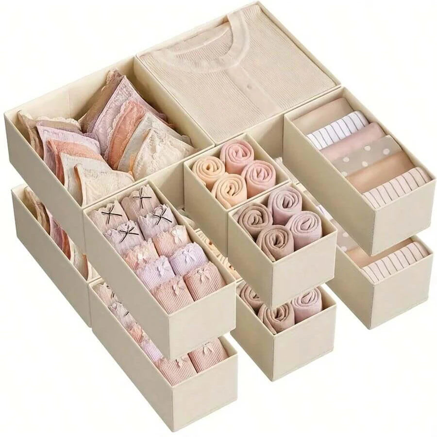 A set of foldable drawer organizer boxes containing various shades of pink and beige underwear, bras, and socks.