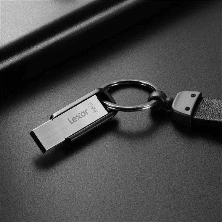 A silver Lexar M400 USB 3.2 flash drive is shown attached to a keyring against a dark background.
