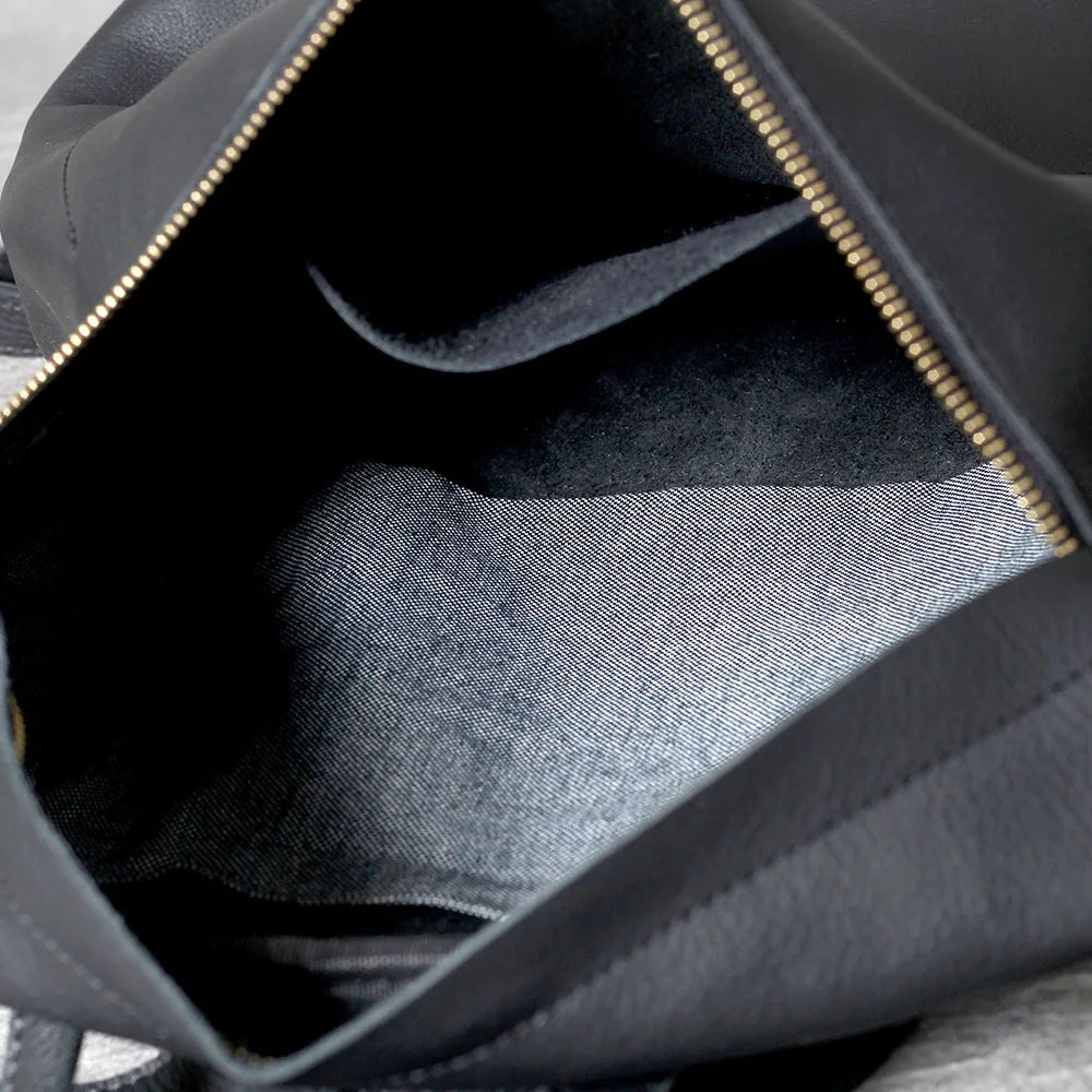 Innenansicht eines schwarzen, echten Kuhfell-Rucksacks mit Lining und Reißverschlussdetails
