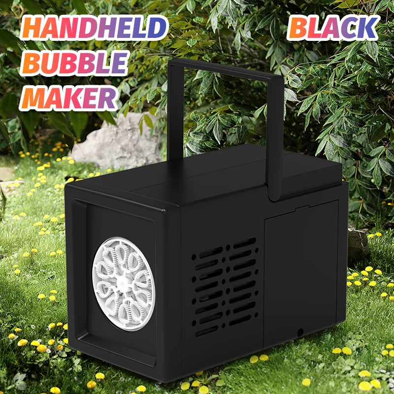 A black handheld bubble maker device is shown outdoors on green grass with foliage in the background.