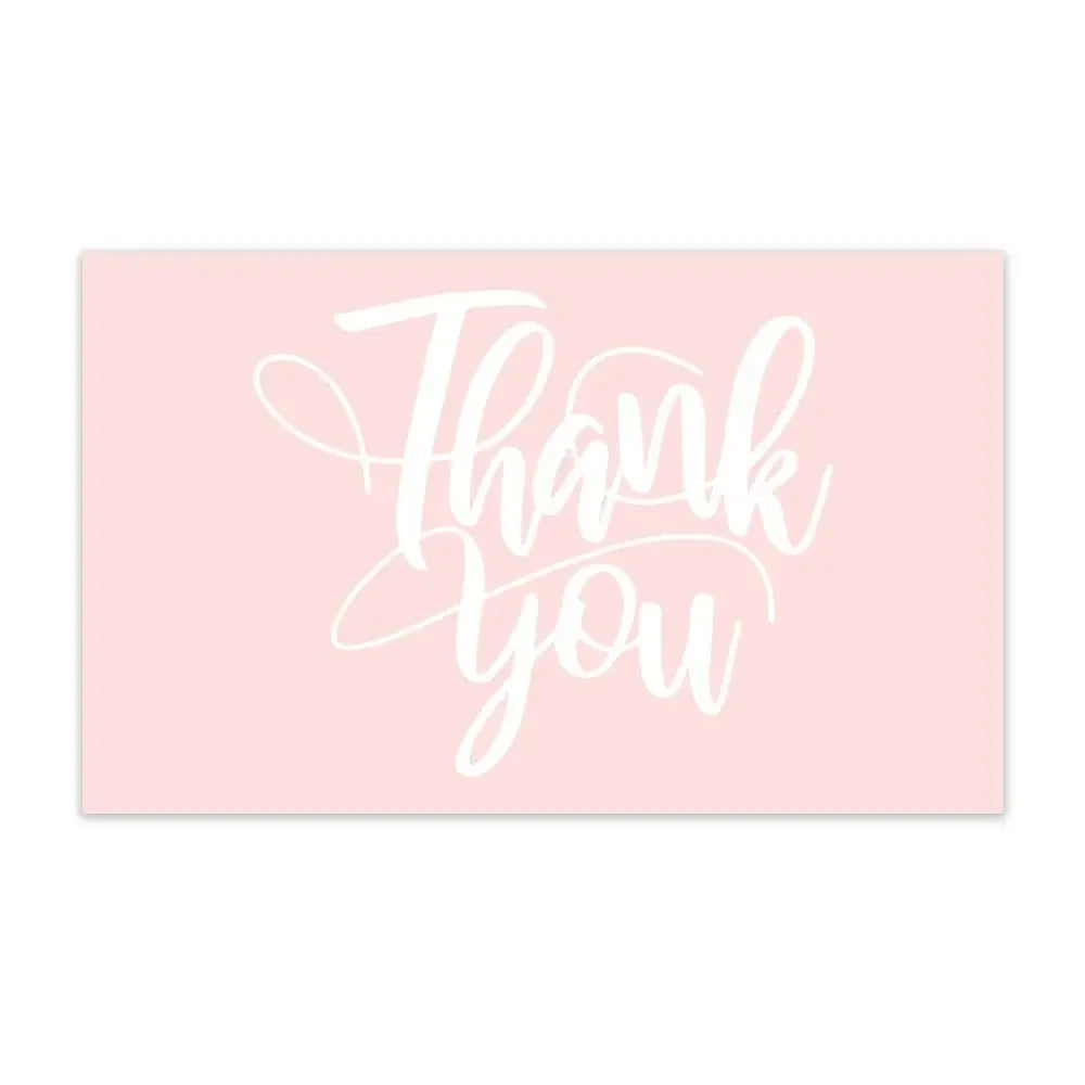 A pink card with white cursive text that reads Thank you