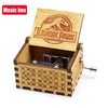 A wooden music box with a Jurassic Park theme featuring an engraved lid and decorative paneling.