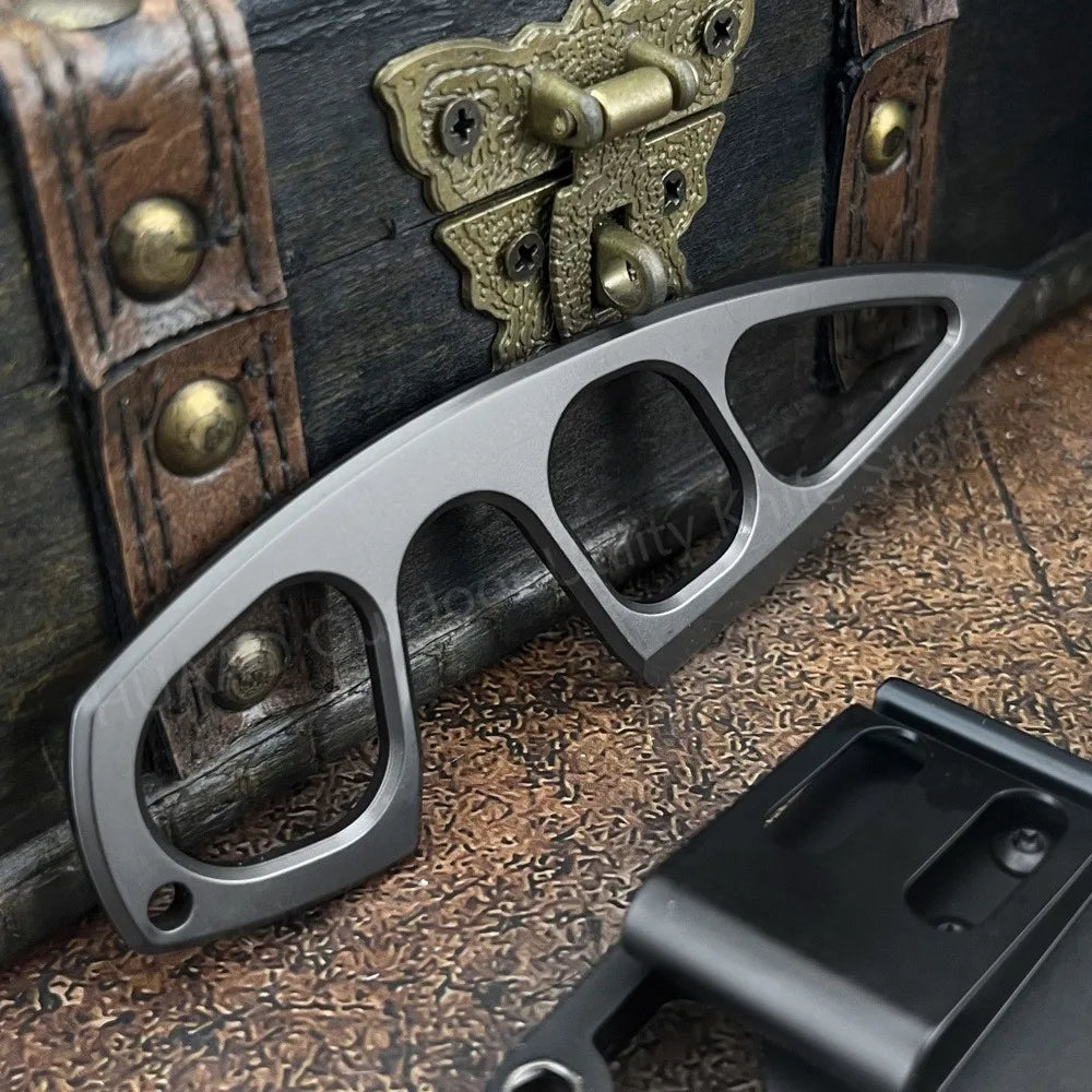 A compact stainless steel neck knife is shown next to an old leather box and a dark metal sheath.