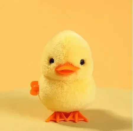 A yellow wind-up walking chicken toy with orange feet against a light background.