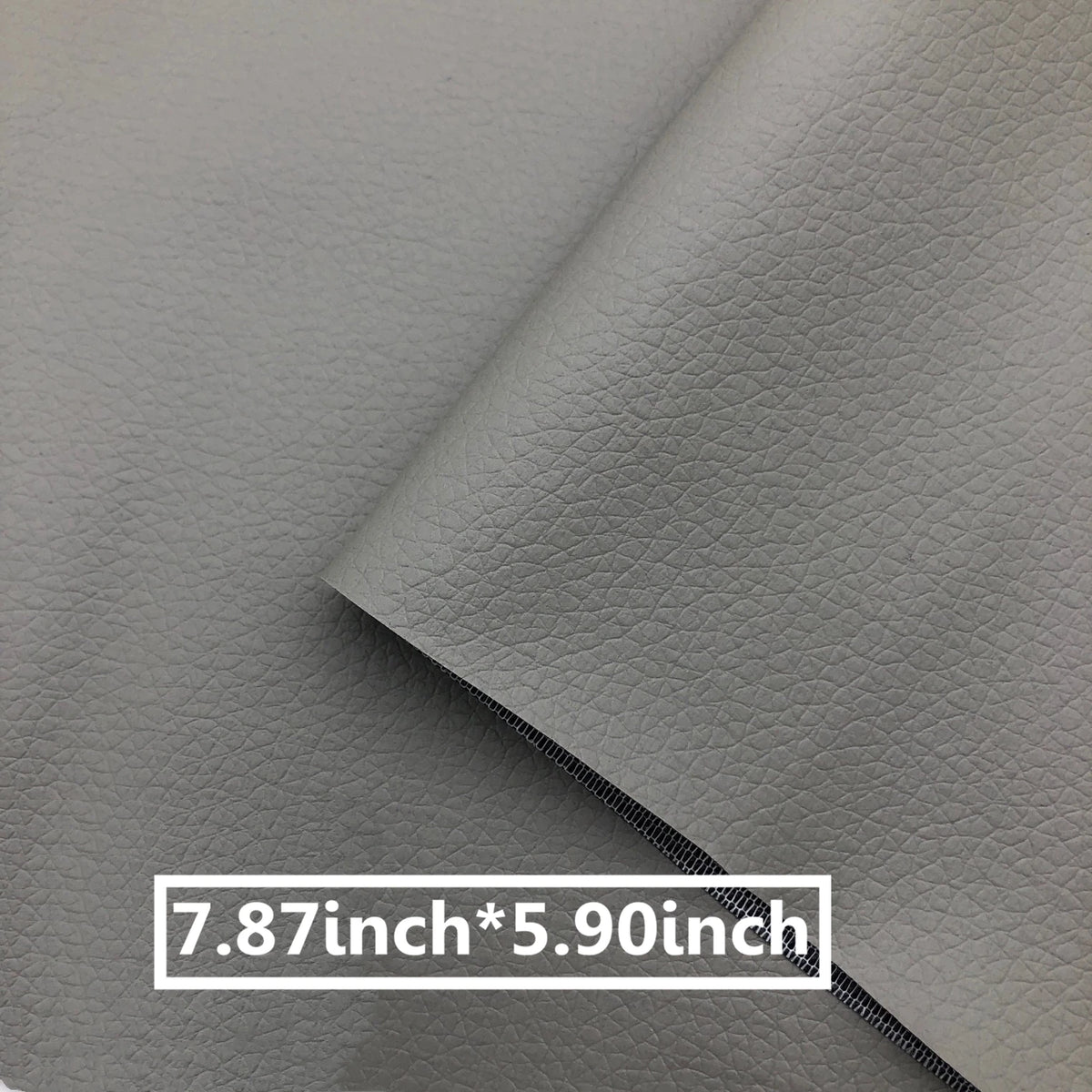 A close-up of a gray leather repair patch with a stitched edge, showing its dimensions 7.87 inches by 5.90 inches.
