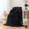 A dark black brushed flannel throw blanket draped on a light-colored surface with color swatches.