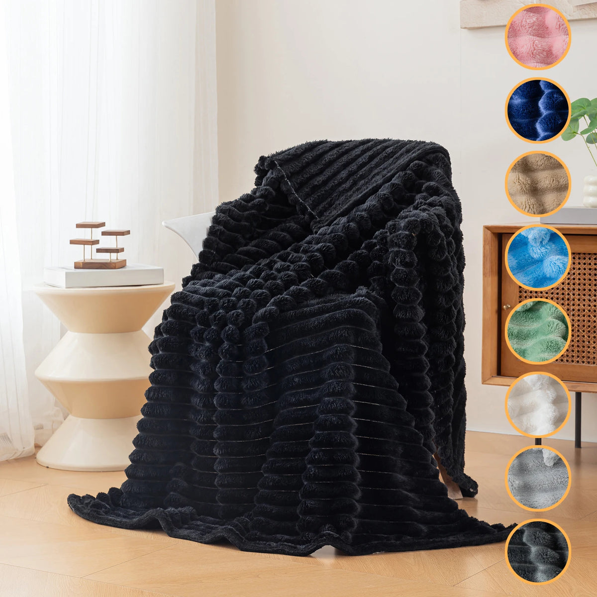 A dark black brushed flannel throw blanket draped on a light-colored surface with color swatches.