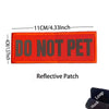 An orange reflective patch embroidered with the text DO NOT PET on a fabric strap.