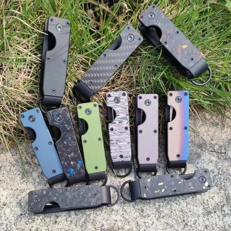 A collection of minimalist aluminum key organizers in various colors and finishes arranged on a natural outdoor background.