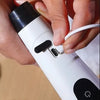 A hand is operating a white electric spin scrubber with interchangeable brush heads.