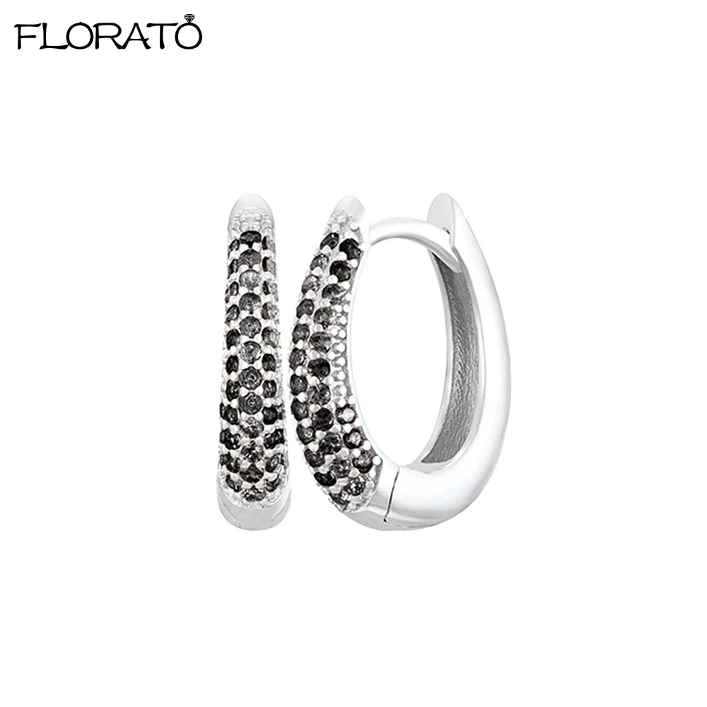 Silver huggie hoop earrings featuring pave-set cubic zirconia stones.