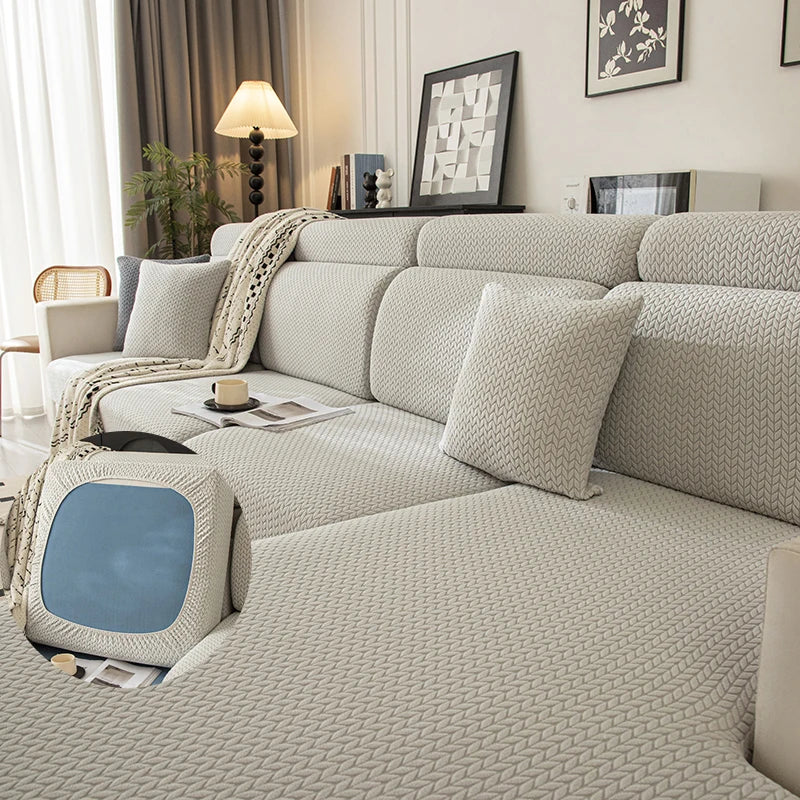 Asiento y funda elástica beige removible con tela texturizada, mostrados en un sofá moderno.