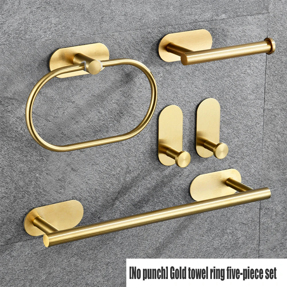 A five-piece gold towel ring set with adhesive mounting hardware displayed on a gray fabric background.