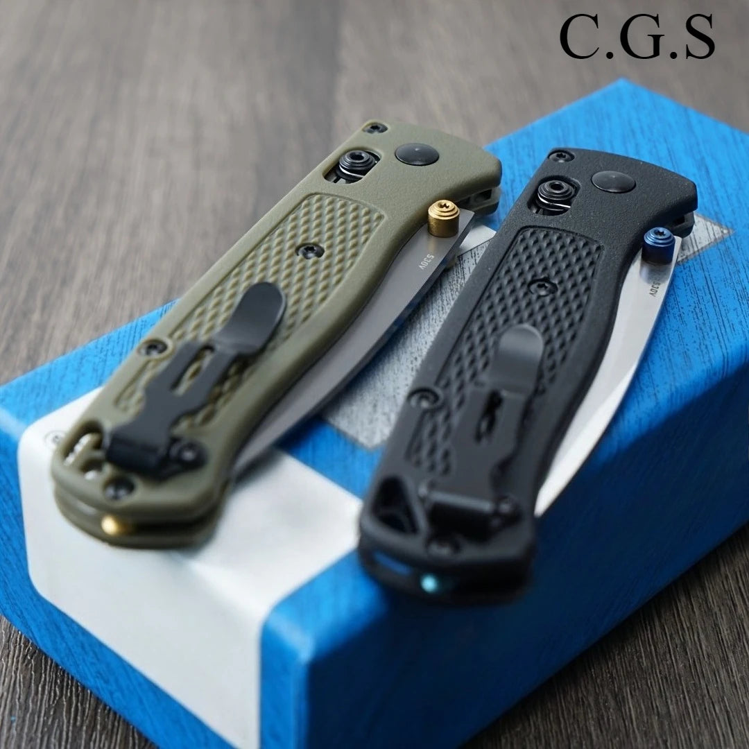A pair of olive green and black ultralight EDC folding knives are displayed on a blue box.