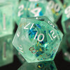 A close-up of a translucent mint green polyhedral die resting on a dark surface, surrounded by other dice.