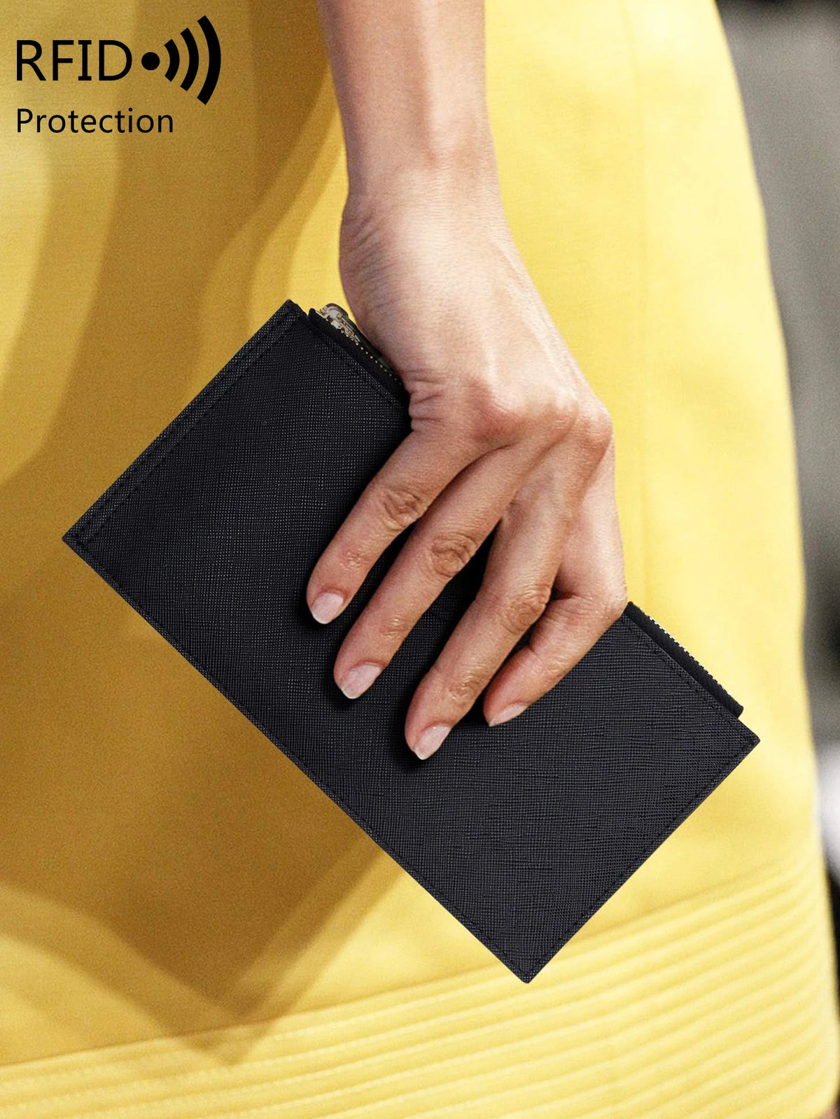 A hand holds a black RFID blocking bifold wallet with a double zipper security feature against a yellow background.