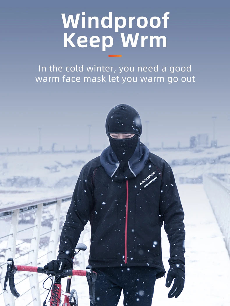 A person wearing a black windproof full face balaclava mask and jacket is cycling outdoors in the snow.