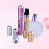 A set of five travel-friendly refillable perfume spray bottles in various metallic colors including pink, gold, and silver.