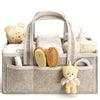 A beige floral diaper organizer bag filled with baby grooming items like brushes and teddy bears.