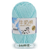 A ball of light blue milk cotton blend yarn with a label featuring a cow and text in Chinese and English.