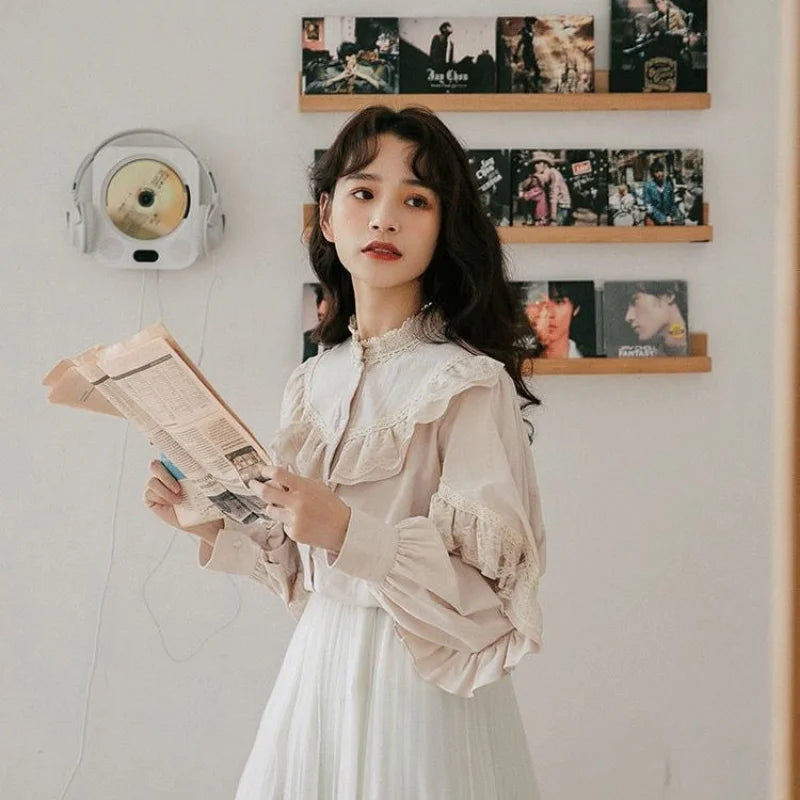 A young woman wearing a cream-colored vintage lace long sleeve blouse and white skirt, holding a newspaper.