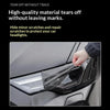 Close-up of smoke black tint film being applied to a car's headlight assembly.