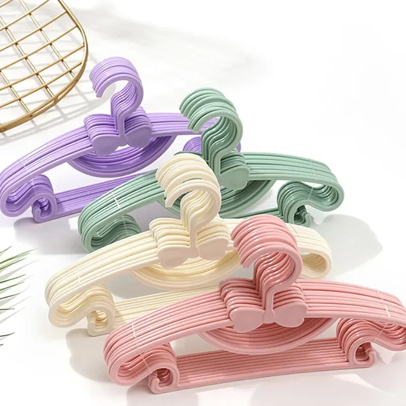 A set of ten adjustable baby clothes hangers in various pastel colors including purple, mint green, cream, and pink.