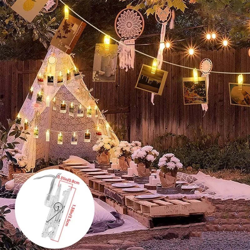 Warm white LED photo clip string lights strung across a wooden fence in an outdoor setting