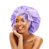 A woman wearing a purple satin sleeping bonnet tied in a bow.
