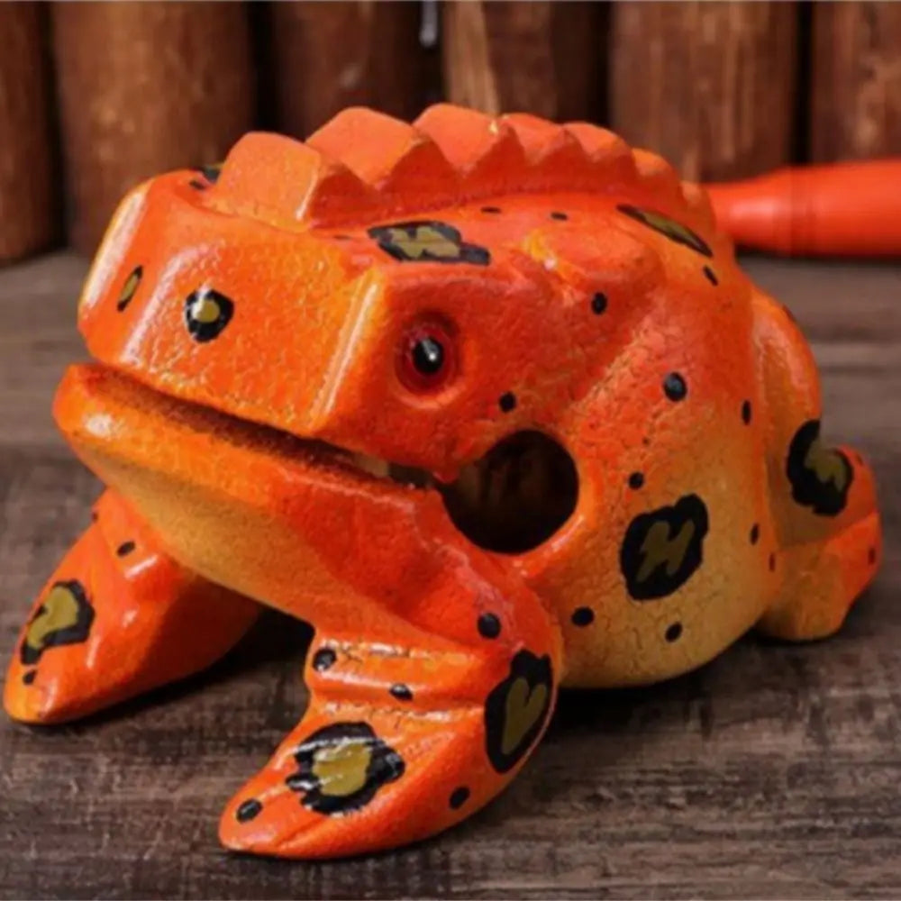 Handcrafted wooden frog guiro rasp percussion instrument with orange and black spotted skin