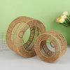 A woven paper rope pendant lampshade in natural brown color resting on a light green background.