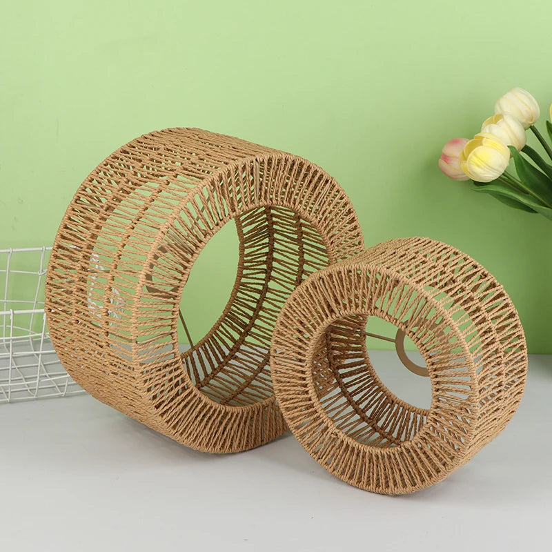 A woven paper rope pendant lampshade in natural brown color resting on a light green background.