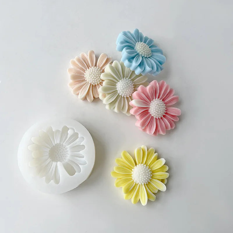 A collection of silicone daisy molds in pastel blue, pink, yellow, and cream colors.