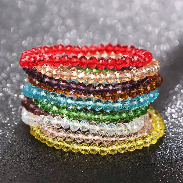 Stack of colorful crystal bead bracelets in various shades of red, purple, blue, green, and yellow