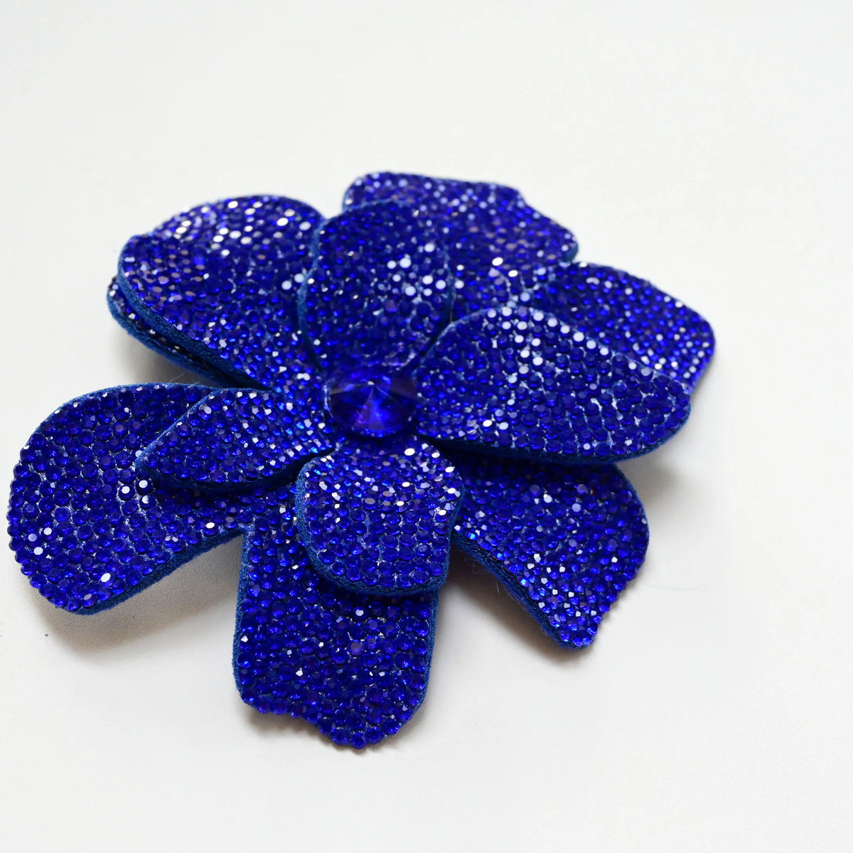 A vibrant royal blue crystal rhinestone flower sew-on patch for clothing and accessories.