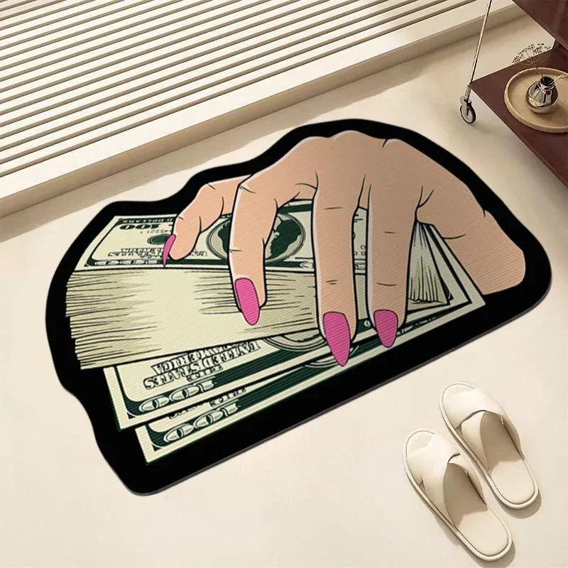 A hand is holding a stack of US dollar bills on a black non-slip bathroom rug.