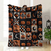 A patchwork throw blanket featuring vintage Halloween prints of pumpkins and moons on a dark fabric.