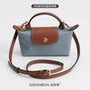 A light blue leather mini bag with brown stitching and a matching leather strap set.