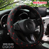 Close-up of a black steering wheel with red embroidered leather stitching inside a car interior.