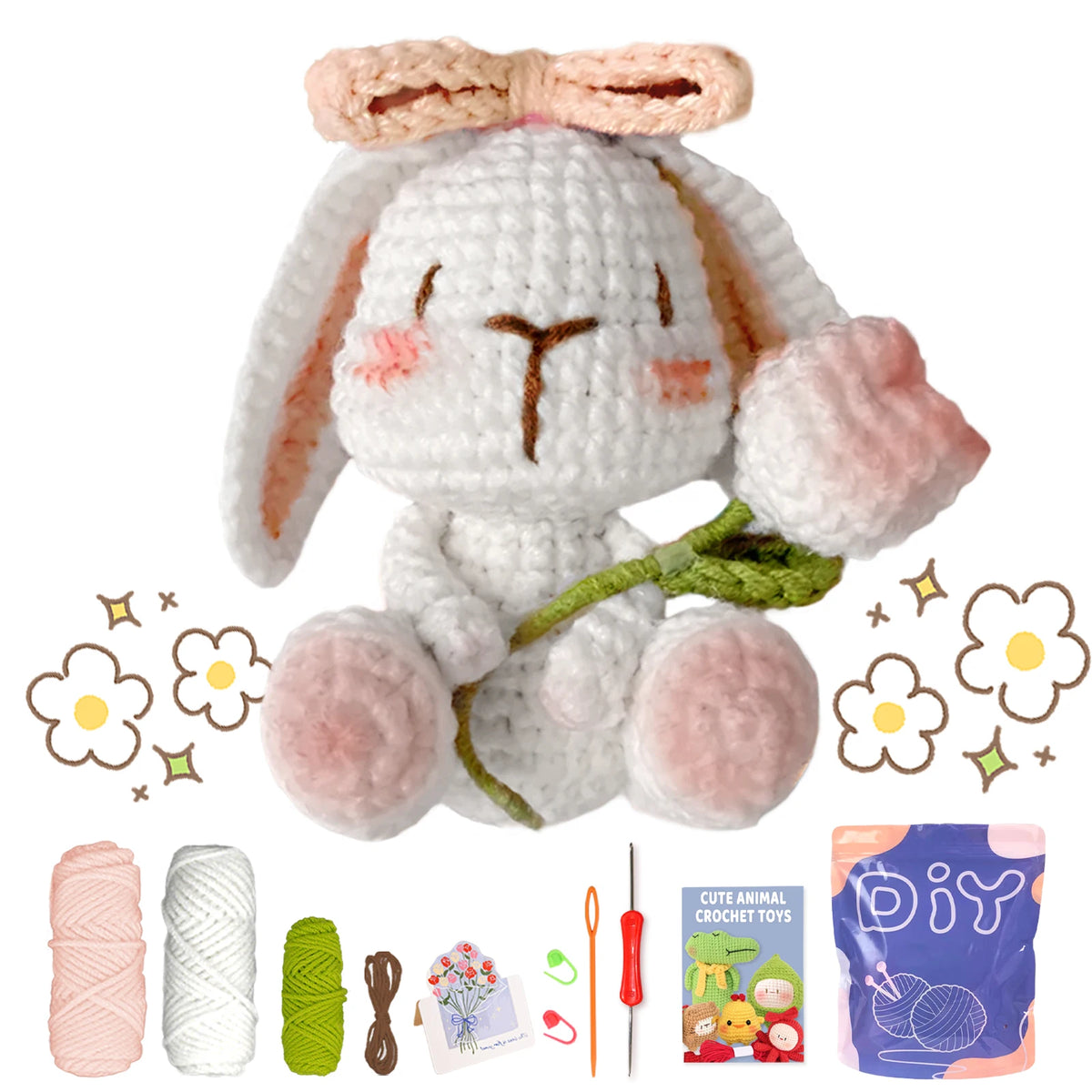 A finished white crochet bunny toy with pink accents, surrounded by yarn, tools, and a DIY kit.