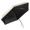 A black compact folding umbrella with a beige canopy is shown open against a white background.