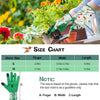 A hand wearing green and floral gardening gloves is shown holding a small trowel in an outdoor garden setting.
