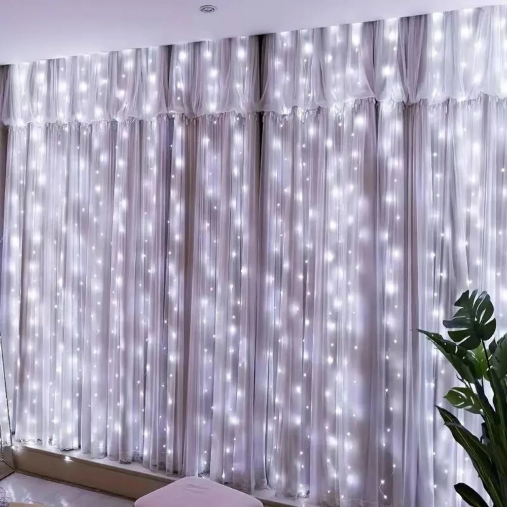 Floor-to-ceiling sheer white curtain illuminated by vertical strings of twinkling fairy lights
