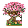A miniature pink sakura treehouse built from micro building blocks with an LED glow.