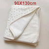 White floral muslin baby blanket folded and displayed on a light surface.