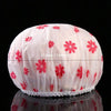 Pink waterproof shower cap with red floral pattern shown from the top.