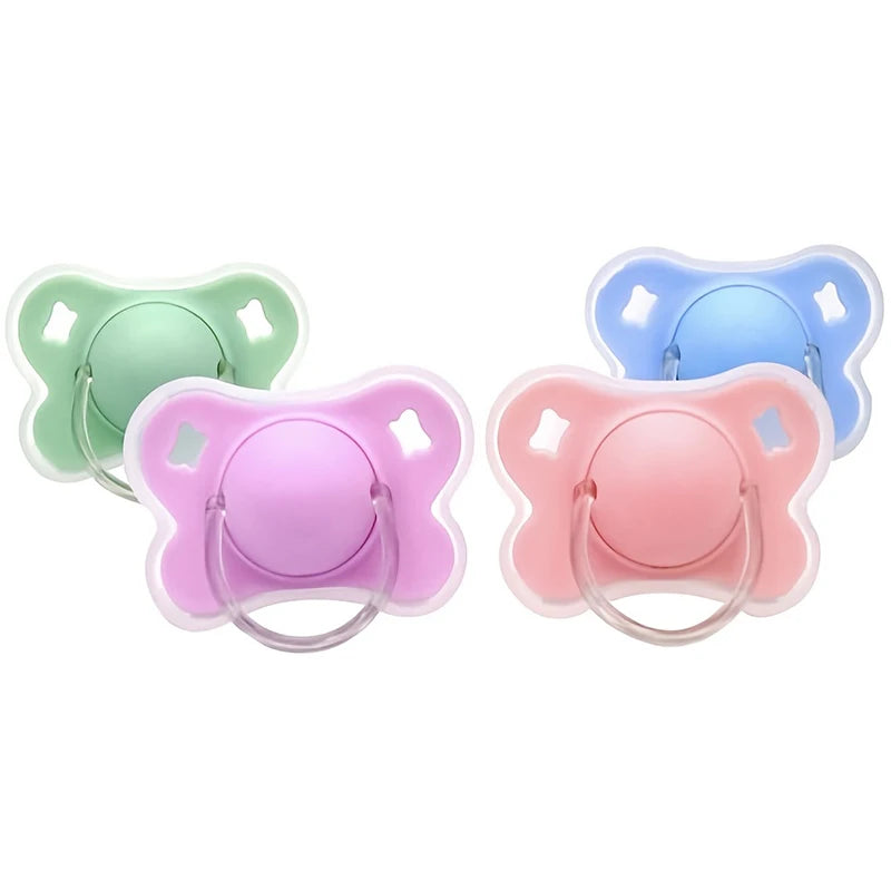 Three silicone baby pacifiers in green, blue, and pink with flower designs.