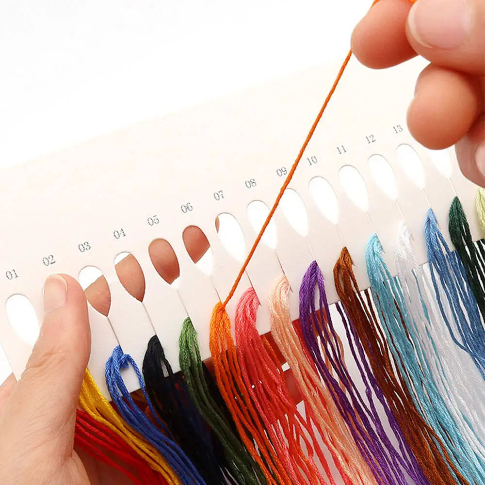 Assorted threads for a mini floral cross stitch kit featuring various colors like red, blue, green, and purple.